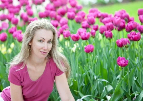 La jeune belle femme dans le parc de printemps avec des tulipes en fleurs — Photo
