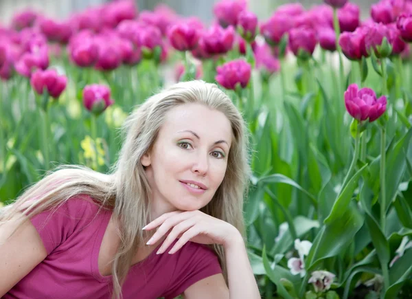 La bella donna giovane in parco di primavera con tulipani fiorenti — Foto Stock
