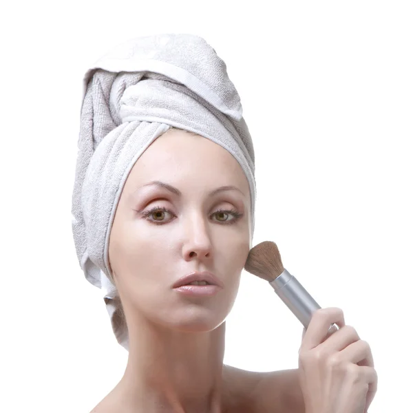 De mooie jonge vrouw in de handdoek met een cosmetische borstel — Stockfoto