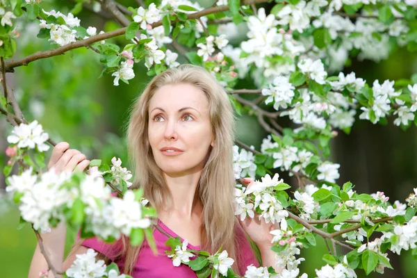 Junge attraktive Frau am blühenden Apfelbaum — Stockfoto