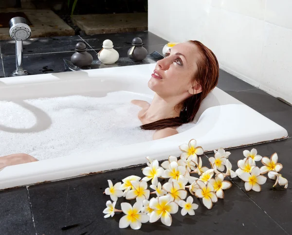 Woman lays in soapsuds in bathing, full water — Stock Photo, Image