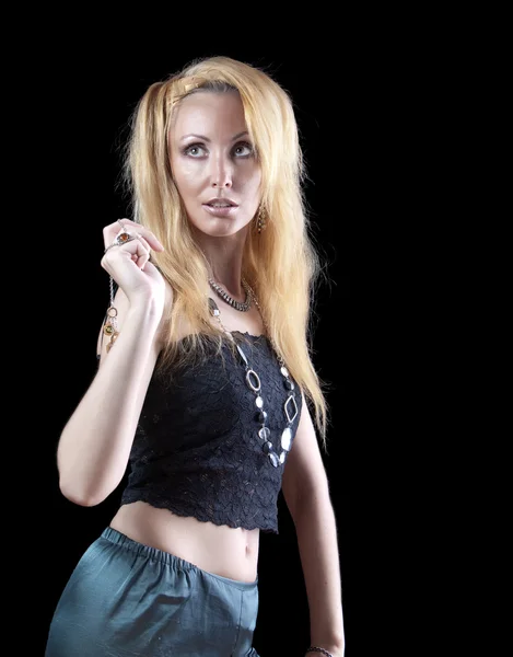 Schöne junge Frau mit langen blonden Haaren und rotem Armband auf dunklem Hintergrund — Stockfoto
