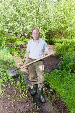bir bahçe yatak yaz cottag tarihinde ilk filizi ile yukarıya adam kazıyor