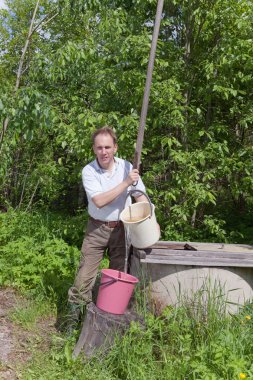 Kuyudaki adam, kovaya su döker.