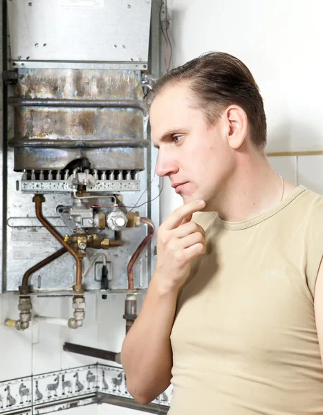 O homem pensa na reparação de um aquecedor de água a gás — Fotografia de Stock