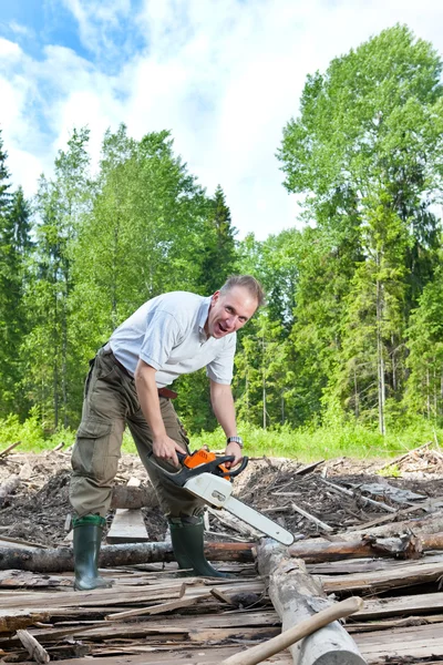 The man in wood saws a tree a chain saw — Stock Photo, Image