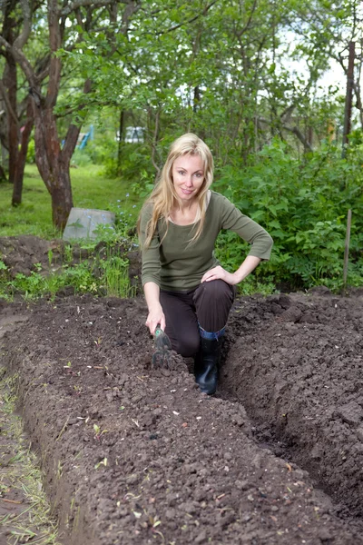 The young woman couch a bed with the first sprouts on a summer cottage — Stock Photo, Image