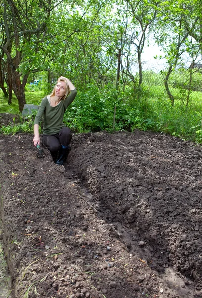 De jonge vrouw Bank een bed met de eerste spruiten op een zomerhuisje — Stockfoto