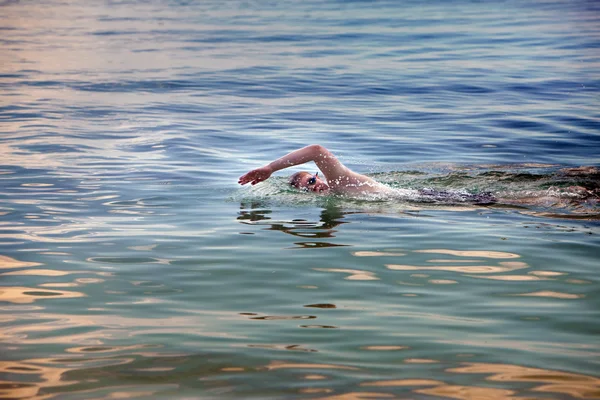 Junger Sportler schwimmt im Meer — Stockfoto