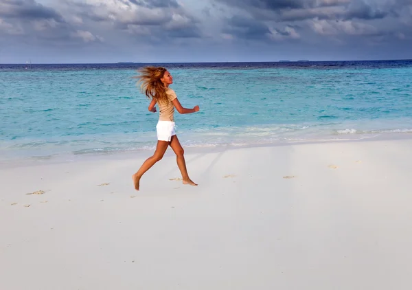 Spor kadın sahil üzerinde çalışır. Maldivler — Stok fotoğraf