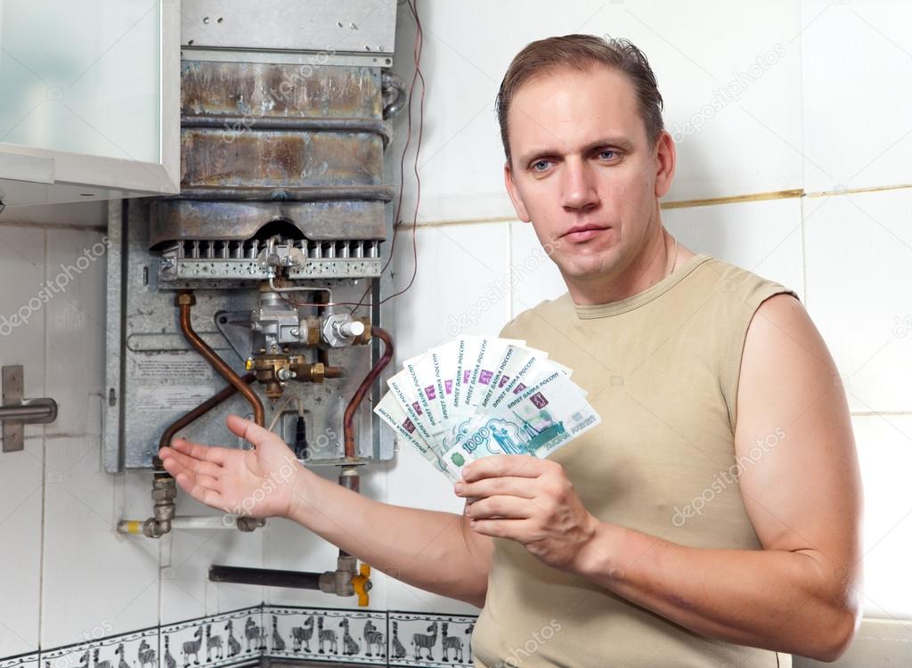 The sad man counts money for repair of a gas water heater