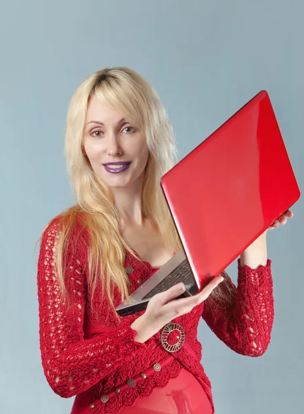 Den unga vackra kvinnan i röd blus med röd laptop — Stockfoto