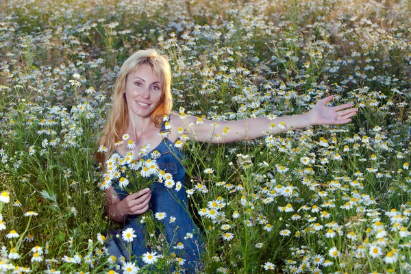 The beautiful happy young woman in the field of camomile — Stock Photo, Image