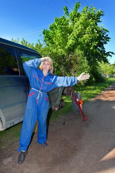 A nő a munka overall próbálja meg helyettesíteni a kerék egy off-road autó — Stock Fotó