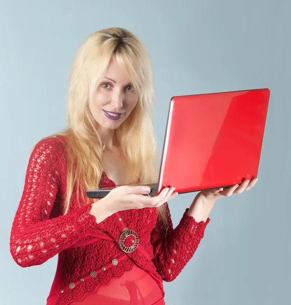 A bela mulher jovem na blusa vermelha com o computador portátil vermelho — Fotografia de Stock