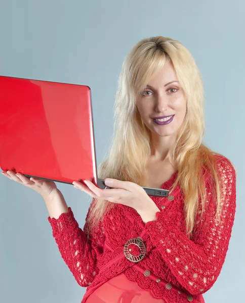 A bela mulher jovem na blusa vermelha com o computador portátil vermelho — Fotografia de Stock