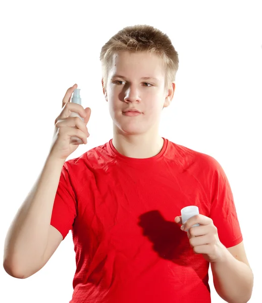 De jongen, de tiener die parfum spuit — Stockfoto