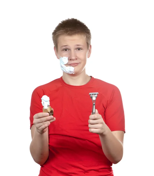 El muchacho, el adolescente la primera vez trata de afeitarse y se confunde . — Foto de Stock