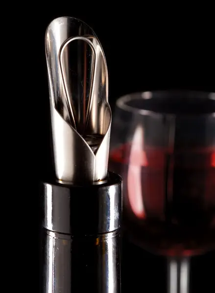 Bottle with a special nozzle for wine pouring and a wine glas — Stock Photo, Image