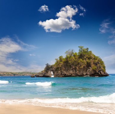 kumlu bir plaj üzerinde okyanus kayaların üzerinden görüntüleyin. Endonezya, bali