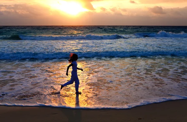 바다 해안 따라 석양에 실행 하는 여자의 실루엣 — 스톡 사진