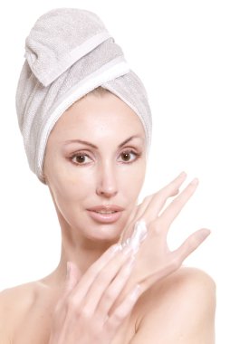 bir havlu içinde güzel bir kadın krem ellerini koyar.