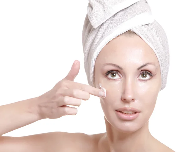 The beautiful young woman in towel with a cosmetic cream — Stock Photo, Image