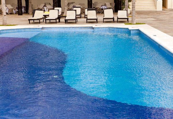 Empty chaise lounges near pool