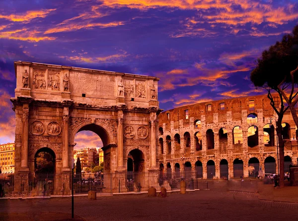 Puesta de sol carmesí brillante sobre el antiguo Coliseo y el arco triunfal. En Roma. Itali. —  Fotos de Stock