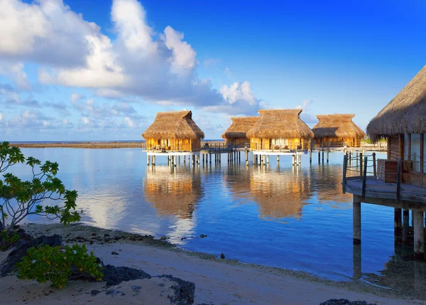 The coast and lodges on water at sunrise — Stock Photo, Image