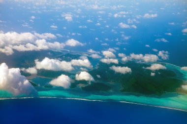 Polinezya. Okyanustaki bulutların arasındaki mercan adası. Hava görünümü