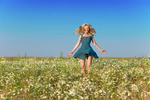 La joven feliz en el campo de las manzanillas —  Fotos de Stock