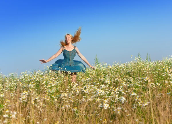 Szczęśliwa młoda kobieta w pole camomiles — Zdjęcie stockowe