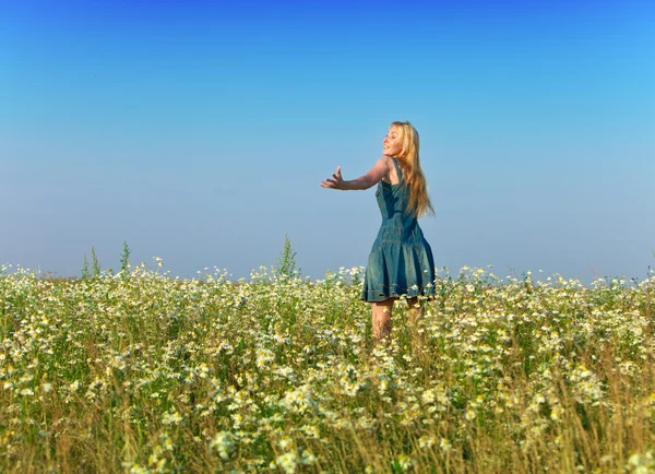 Счастливая молодая женщина в поле ромашки — стоковое фото