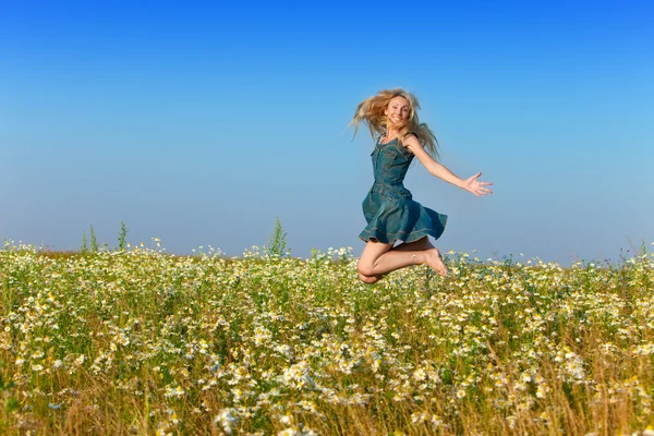 La joven feliz en el campo de las manzanillas —  Fotos de Stock