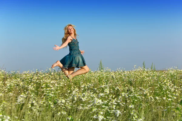 La joven feliz en el campo de las manzanillas —  Fotos de Stock