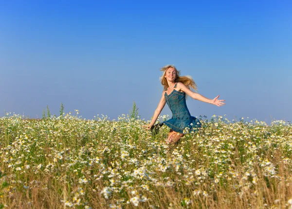 La joven feliz en el campo de las manzanillas —  Fotos de Stock