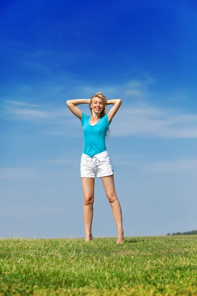 快乐的女人跳在夏天绿色字段对蓝蓝的天空中 — 图库照片