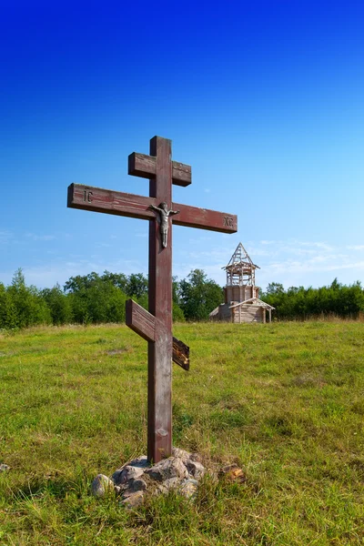 Cruz en honor de la base de la iglesia y en construcción iglesia ortodoxa en una colina —  Fotos de Stock