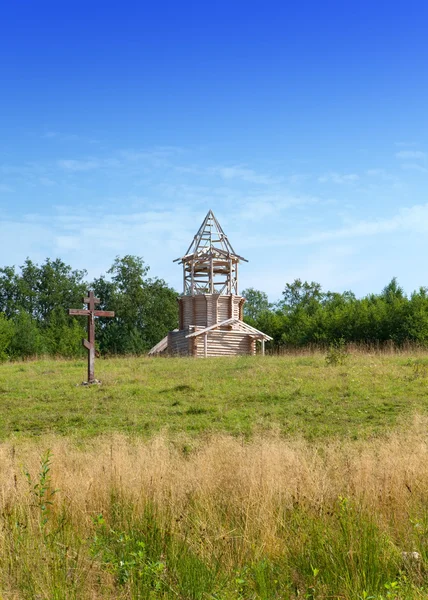 Cruz en honor de la base de la iglesia y en construcción iglesia ortodoxa en una colina —  Fotos de Stock