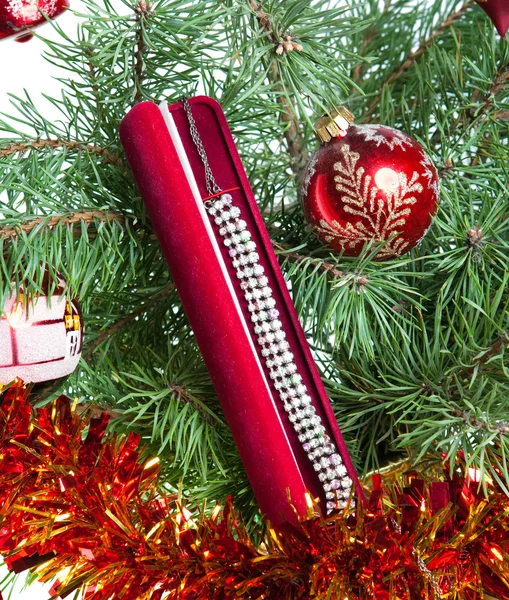New Year's bollar på grenar av en julgran och gåvor — Stockfoto