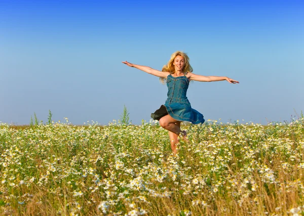 The happy young woman in the field of camomiles Stock Picture