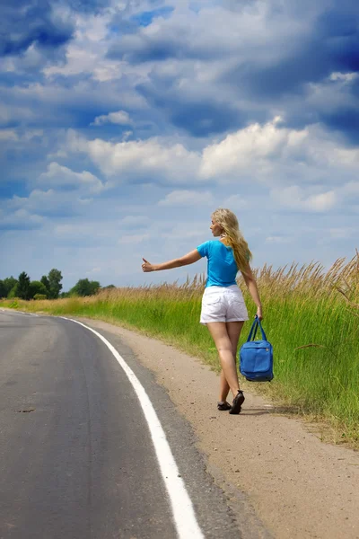 Hitchhiking chica votos en la carretera Fotos De Stock