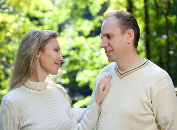 Pareja cariñosa sobre un fondo de follaje verde — Foto de Stock