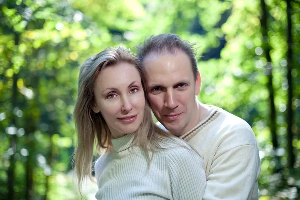 Älskande par på en bakgrund av grön foliag — Stockfoto