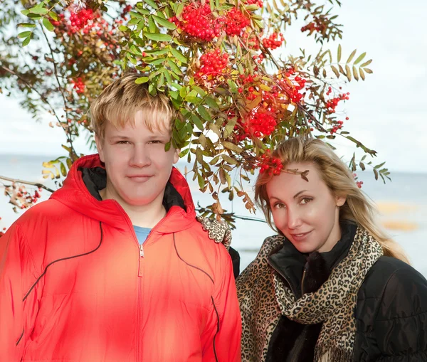 Young people at a mountain ash bush — Stock Photo, Image