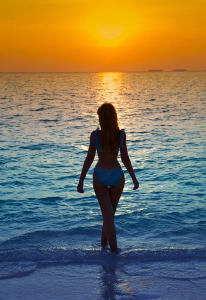 Silhueta da mulher contra um pôr-do-sol no oceano — Fotografia de Stock