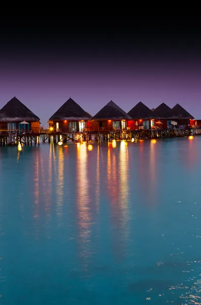 Houses on piles on water at night — Stock Photo, Image