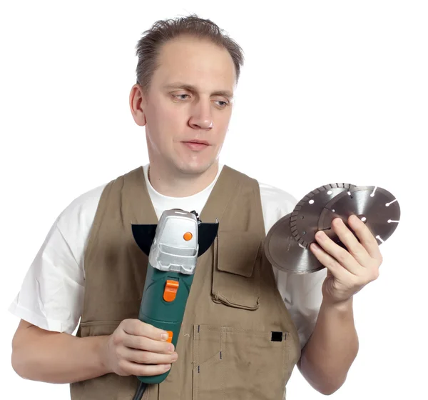 The man in working overalls with the detachable machine and saw disks — Stock Photo, Image