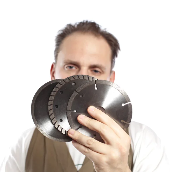 The man in working overalls with the detachable machine and saw disks — Stock Photo, Image
